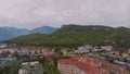 Top view of small resort town. Hotels, houses and roads. Green hills around. Rooftops. Panorama.