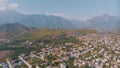 Top view of small resort town. Hotels, houses and roads. Green hills around. Rooftops. Panorama.