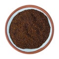 Top view of a small terracotta spice bowl filled with chili powder isolated on a white background