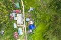 Top view of a small village composed of a few houses and a central open basketball court, in a remote sitio or village near the