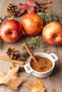 Top view of small white bowl with brown sugar, red royal gala apples with cinnamon sticks and autumn leaves, with selective focus,