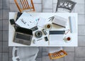 Top view of a small white meeting table with laptops, coffee, calculator, papers, ring binder and four casual chairs on a gray Royalty Free Stock Photo