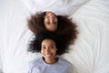 Top view African American teen daughter lying on bed with mother Royalty Free Stock Photo