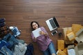 Top view smiling asian woman laying on wooden floor and writing in note book