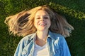 Top view of smiling happy face of young beautiful woman lying on green grass, sunny day Royalty Free Stock Photo