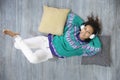 Top view of smiling and relaxed latin girl listening to music lying on the floor of her house Royalty Free Stock Photo
