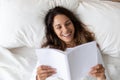 Top view smiling woman reading book, resting in bed Royalty Free Stock Photo