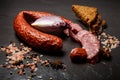 Top view of smoked dry sausage with onion and rye bread slices Royalty Free Stock Photo