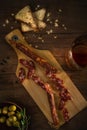 Top view of smoked sausages with chips, olives and glass of wiskey on wooden surface Royalty Free Stock Photo
