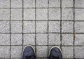 Top view on sneakers and square sidewalk Royalty Free Stock Photo