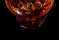 Top of view of snifter of brandy in elegant typical cognac glass on black background