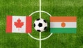 Top view soccer ball with Canada vs. Niger flags match on green football field