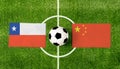 Top view soccer ball with Chile vs. China flags match on green football field