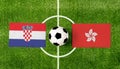 Top view soccer ball with Croatia vs. Hong Kong flags match on green football field
