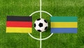 Top view soccer ball with Germany vs. Gabon flags match on green football field