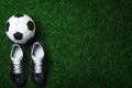 Top view of soccer ball and pair of football sports shoes on soccer field. Generative AI Royalty Free Stock Photo