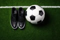 Top view of soccer ball and pair of football sports shoes on soccer field. Generative AI Royalty Free Stock Photo