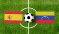 Top view soccer ball with Spain vs. Venezuela flags match on green football field