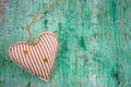 Soft toy in a shape of heart on a mint green shabby wooden background copy space