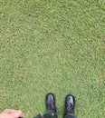 Top view, soldier in training uniform and combat boots standing on green grass.