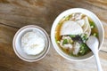 Top view Soup with pock, pock stick, mushroom, vegetable in white bowl near have rice in small bowl on wood table. with copy space