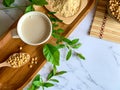 Top view of soymilk cups,soybean seeds on wooden spoon and soy milk powder in a wooden plate Royalty Free Stock Photo