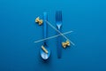 Top view of spaghetti on blue plastic spoon upside down and fork near two kinds of pasta on blue background. Royalty Free Stock Photo