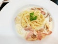 Top view of spaghetti carbonara with cream sauce, bacon and mushrooms on white plate. Royalty Free Stock Photo