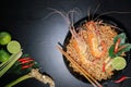 Top view of Spicy instant noodles soup with rivers shrimp on top, on black table background. Tom Yum Kung name in Thailand Foods