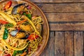 Top view of spicy spaghetti seafood on a wood plate on wood table Royalty Free Stock Photo