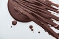 Top view of spilled dark chocolate and chocolate drops on white background. Royalty Free Stock Photo