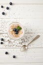 top view of spoon, chia pudding dessert with blueberries and oatmeal on white wooden surface Royalty Free Stock Photo