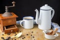 Top view of spoon, cloth, brown sugar, cup with coffee, coffee pot and old grinder on wooden table and black background Royalty Free Stock Photo