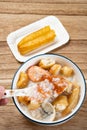 spoon taking out crab from seafood porridge with deep-fried dough sticks