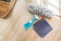 Top view of Spray bottle in a side view with blue liquid detergent inside on the wooden floor with rag and grey feather duster. Royalty Free Stock Photo