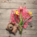 Top view of spring flowers bouquet. Yellow daffodils and pink tulip on wooden background. Copy space Royalty Free Stock Photo