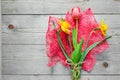 Top view of spring flowers bouquet. Yellow daffodils and pink tulip on wooden background. Copy space Royalty Free Stock Photo