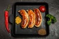 top view square pan with sausages, mustard, chili and basil
