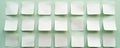 Top view of square white paper stickers with curved edges on green background. Blank labels arranged in rows. Empty note pads Royalty Free Stock Photo