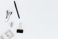 Top view of a stack of $100 bills secured with a binder clip, stapler, pen, and office supplies on a clean white background Royalty Free Stock Photo