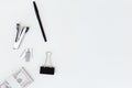 Top view of a stack of $100 bills secured with a binder clip, stapler, pen, and office supplies on a clean white background Royalty Free Stock Photo