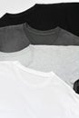 Top view stack of black, grey and white monochrome t-shirt on white background, copy space