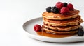 Top view of a stack of fluffy pancakes on white plate, drizzled with maple syrup and topped with fresh berries Royalty Free Stock Photo