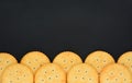 Top view stack of round cheese cracker cookies with sugar on black color background, copy space