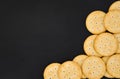 Top view stack of round cheese cracker cookies with sugar on black color background, copy space