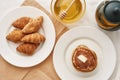 Top view of stack of sweet tasty pancakes, croissants, honey in a bowl with dipper and a teapot, Breakfast served on the