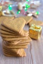 Top view of stacked heart shaped gingerbread cookies, on wooden background with Christmas decorations and defocused lights