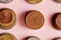 top view of stacks of various coins on pink