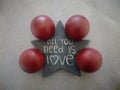 Top view of a star with a quote  all you need is love and four red balls on the floor Royalty Free Stock Photo