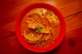 Top view of steamed soup of Momo served in a red bowl. A popular Nepalese food that is also common in Chiana, Bhutan